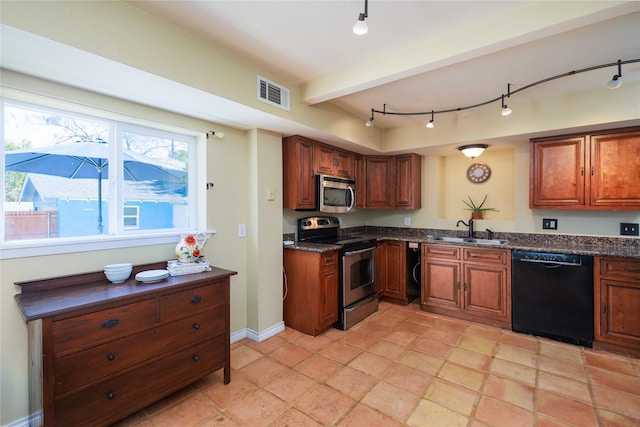 kitchen with sink, dark stone counters, and appliances with stainless steel finishes