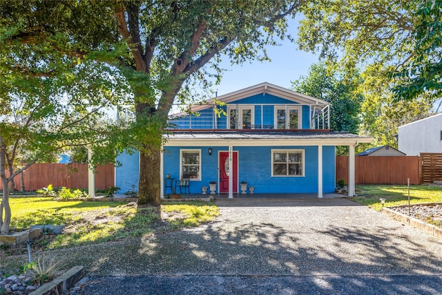 view of front of property with a front lawn, solar panels, and a porch