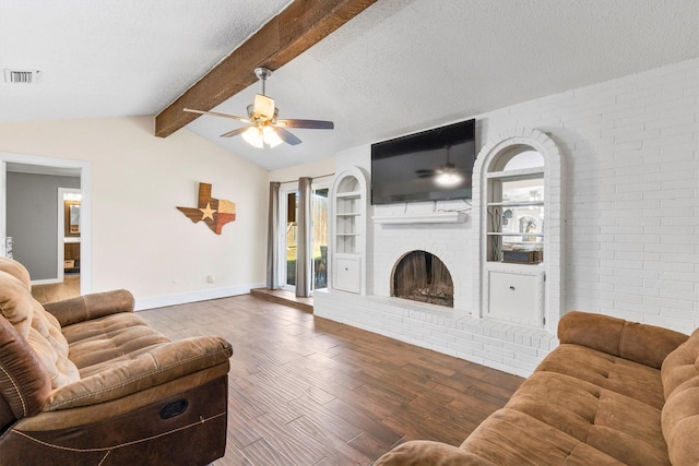 living room featuring hardwood / wood-style flooring, ceiling fan, lofted ceiling with beams, a textured ceiling, and a brick fireplace