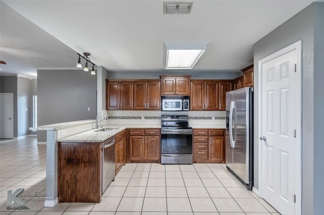 kitchen featuring light tile patterned floors, stainless steel appliances, visible vents, a sink, and a peninsula