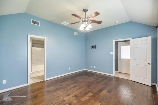 unfurnished bedroom with visible vents, vaulted ceiling, and wood finished floors