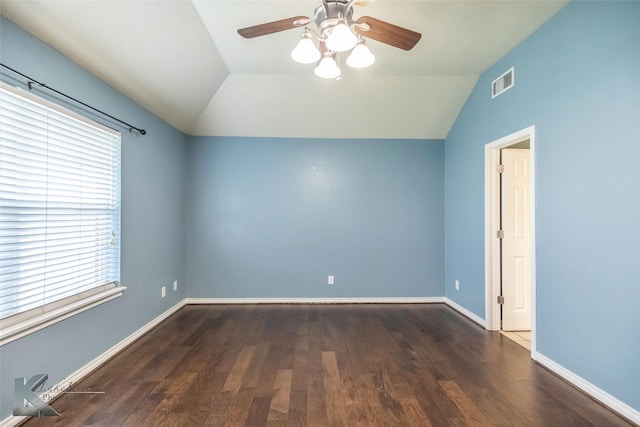 empty room featuring visible vents, vaulted ceiling, baseboards, and wood finished floors