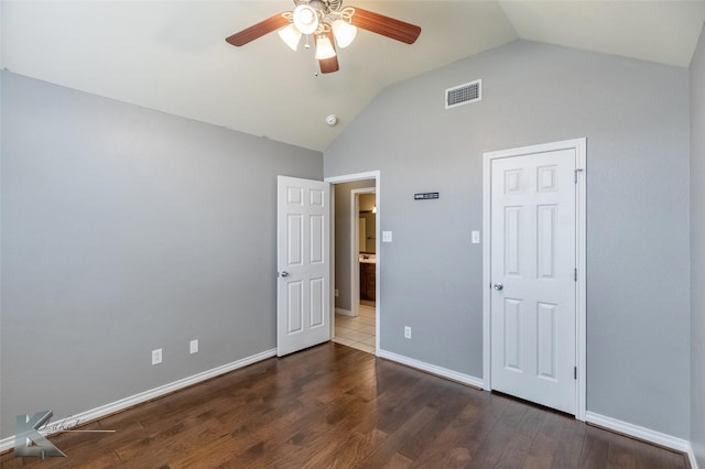 unfurnished bedroom featuring lofted ceiling, wood finished floors, a ceiling fan, visible vents, and baseboards