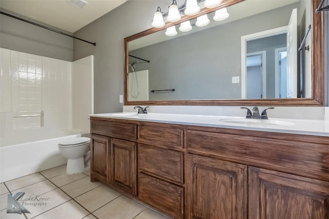 bathroom with double vanity, a sink, toilet, and tile patterned floors