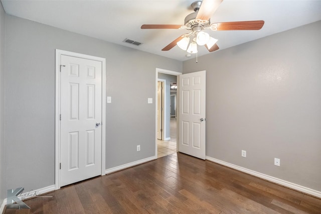 unfurnished bedroom with ceiling fan, wood finished floors, visible vents, and baseboards