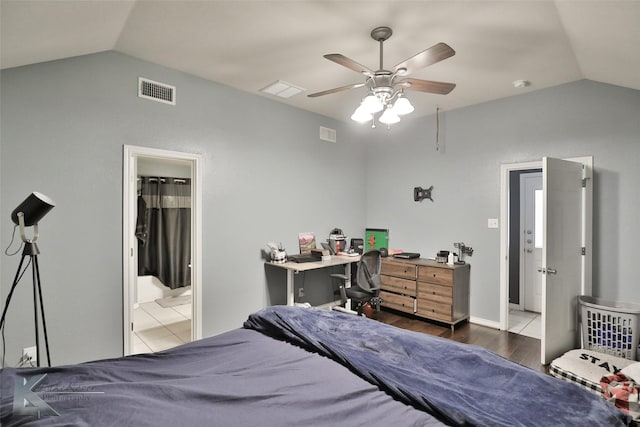 bedroom with ensuite bathroom, lofted ceiling, dark hardwood / wood-style floors, and ceiling fan