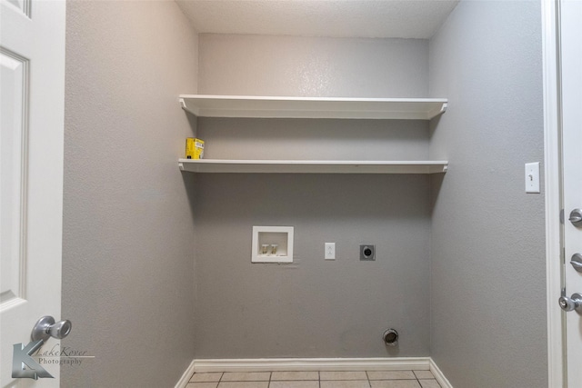 laundry room featuring hookup for a washing machine, laundry area, baseboards, tile patterned floors, and electric dryer hookup