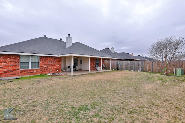 back of house featuring central AC unit, a yard, and a patio