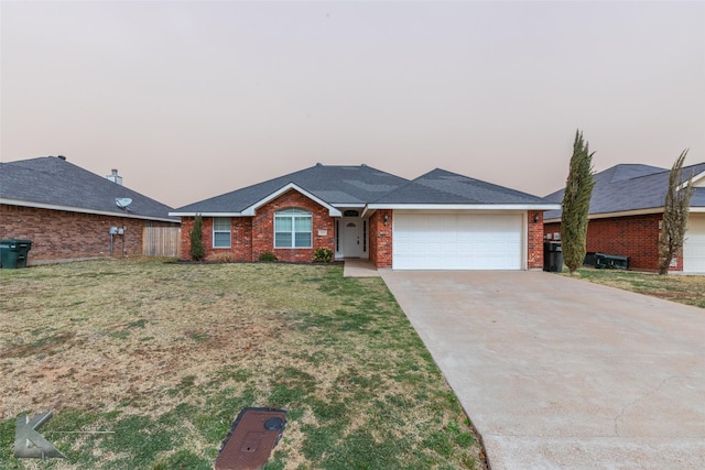 ranch-style house with an attached garage, brick siding, driveway, and a front yard