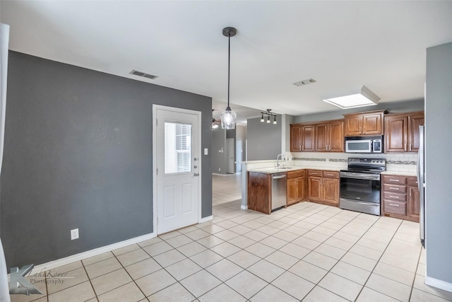 kitchen featuring a peninsula, visible vents, stainless steel appliances, and a sink