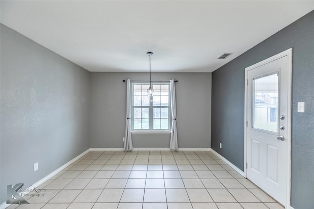 empty room featuring light tile patterned floors, baseboards, and visible vents