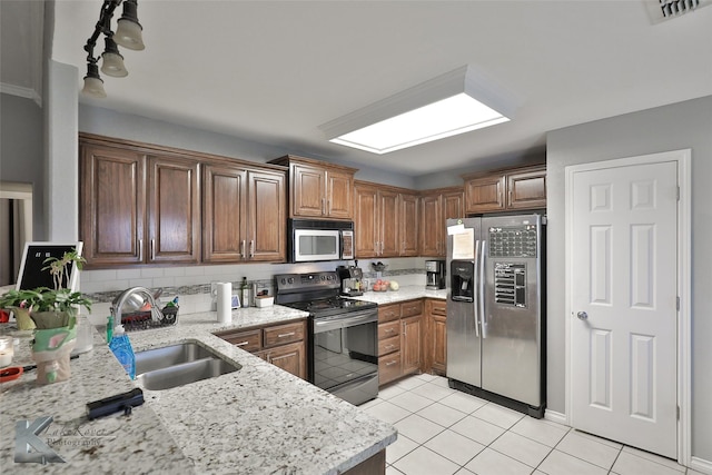 kitchen featuring sink, stainless steel appliances, tasteful backsplash, light stone countertops, and light tile patterned flooring