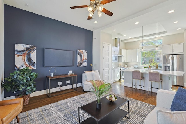 living room featuring dark wood-type flooring and ceiling fan