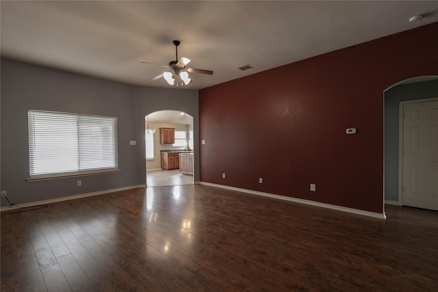 empty room with dark wood-type flooring and ceiling fan