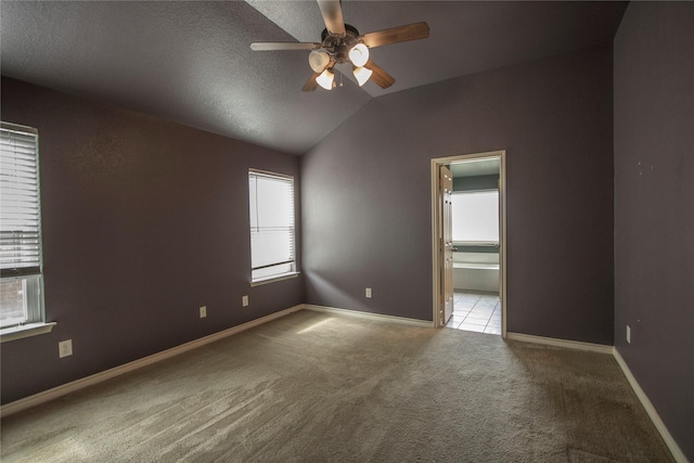 carpeted spare room featuring lofted ceiling, a textured ceiling, and ceiling fan