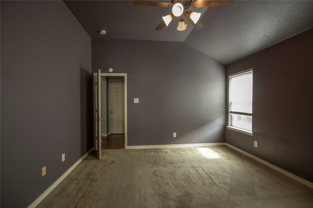 spare room featuring ceiling fan, carpet flooring, and vaulted ceiling