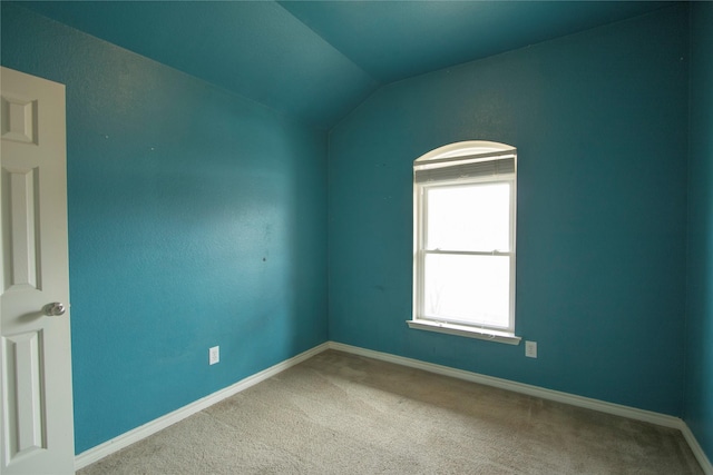 carpeted spare room featuring lofted ceiling