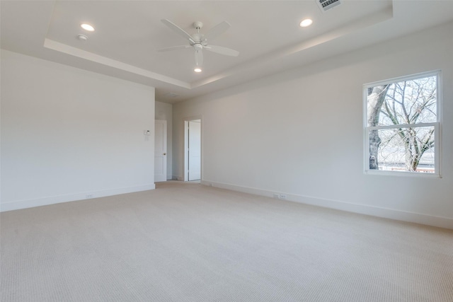 unfurnished room with light carpet, a raised ceiling, and ceiling fan