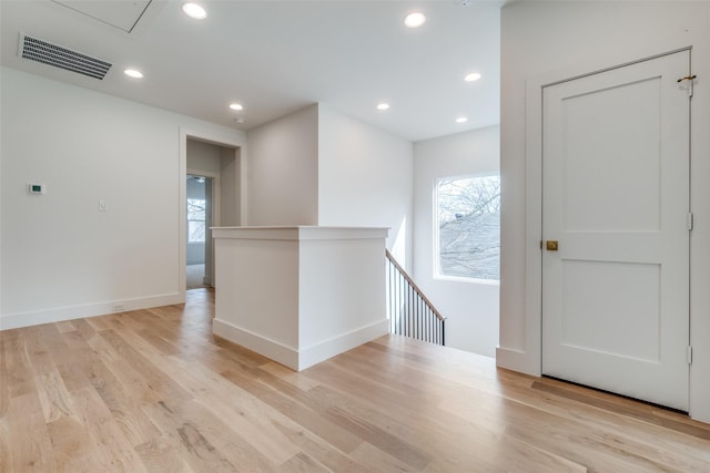 spare room featuring light hardwood / wood-style flooring and a healthy amount of sunlight