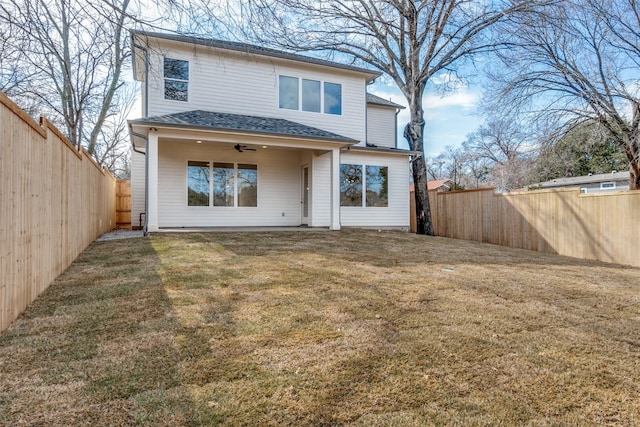 back of house featuring ceiling fan and a yard