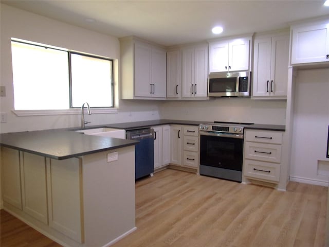 kitchen featuring stainless steel appliances, light hardwood / wood-style floors, sink, and white cabinets