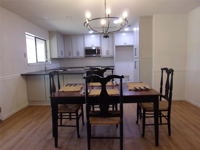 dining area with an inviting chandelier, sink, and hardwood / wood-style flooring