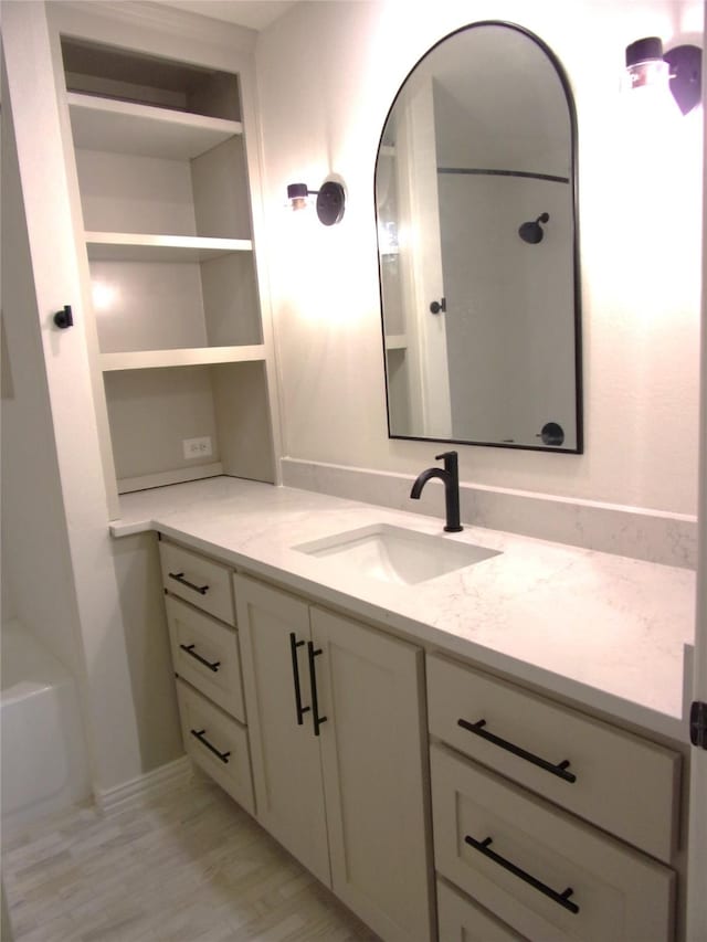 bathroom with hardwood / wood-style flooring, vanity, and shower / bathing tub combination