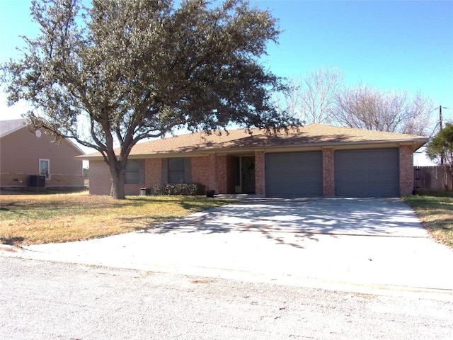 single story home featuring a garage, a front yard, and central air condition unit