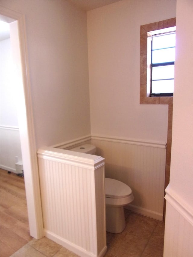 bathroom with tile patterned floors, radiator heating unit, and toilet