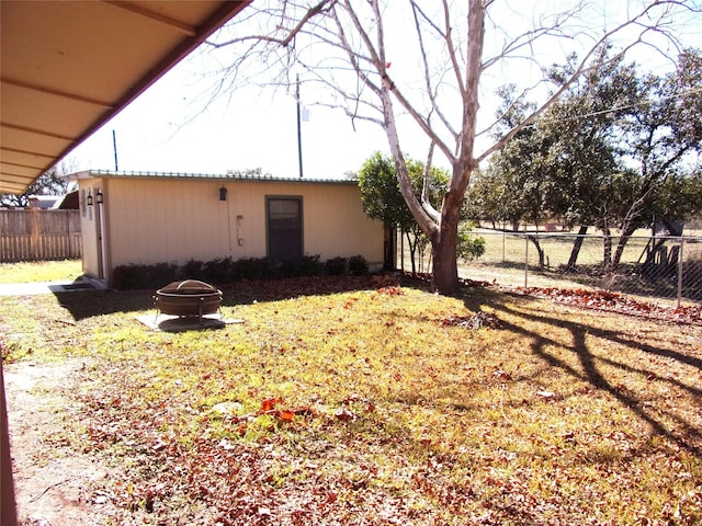 view of property exterior featuring an outdoor fire pit and a yard