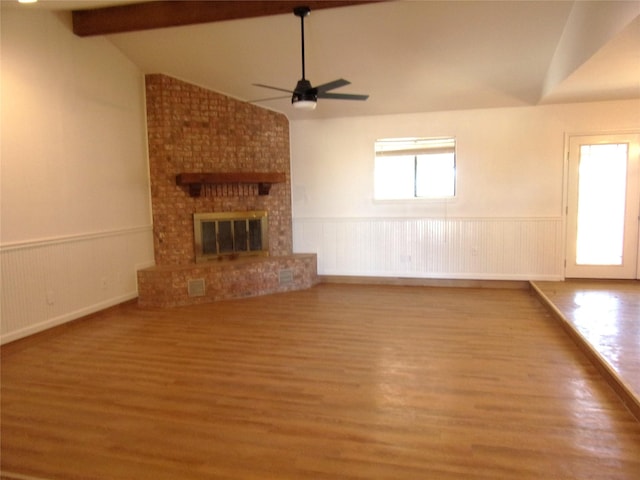 unfurnished living room featuring lofted ceiling with beams, wood-type flooring, ceiling fan, and a fireplace