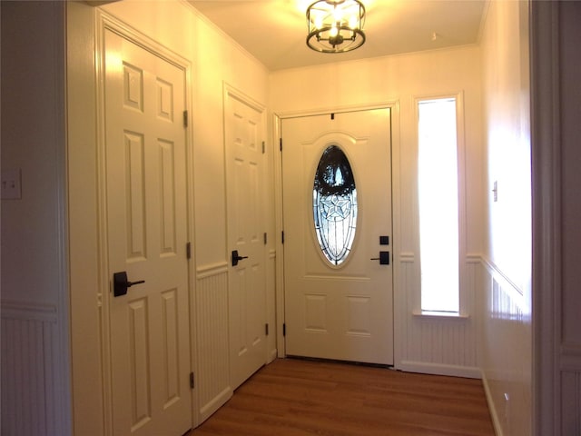 entrance foyer with ornamental molding and hardwood / wood-style floors