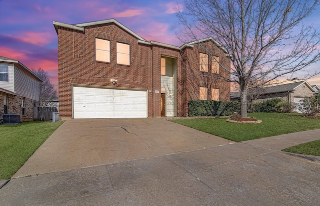 view of front facade with brick siding, an attached garage, a front lawn, central air condition unit, and driveway