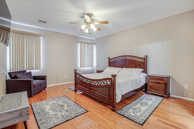 bedroom with visible vents, baseboards, and wood finished floors