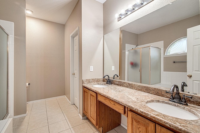 bathroom featuring tile patterned flooring, a shower stall, and a sink