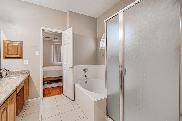 bathroom with vanity, a bath, a shower stall, and tile patterned flooring