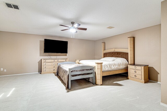 carpeted bedroom with visible vents, a textured ceiling, and baseboards