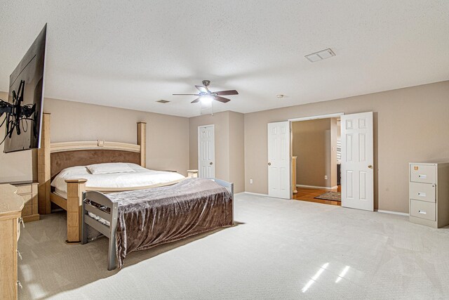 bedroom featuring visible vents, baseboards, carpet flooring, a textured ceiling, and a ceiling fan