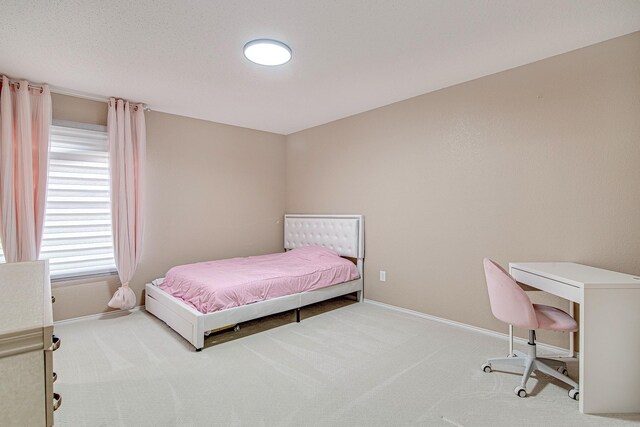 carpeted bedroom featuring baseboards