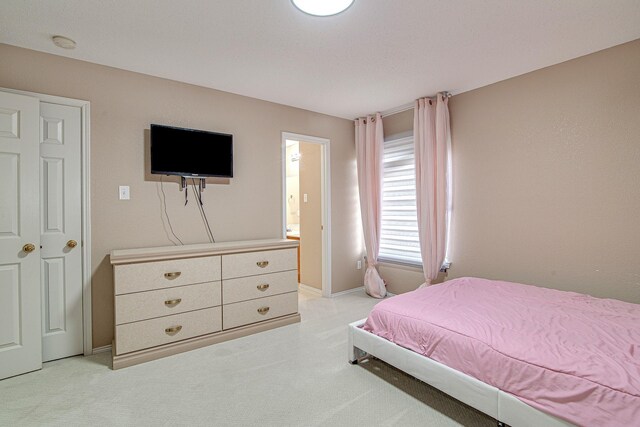 bedroom with light colored carpet and baseboards