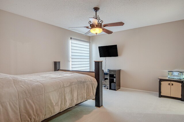 bedroom featuring light colored carpet, a textured ceiling, baseboards, and ceiling fan