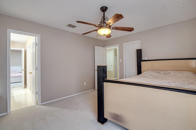 unfurnished bedroom featuring ceiling fan, light colored carpet, visible vents, and baseboards