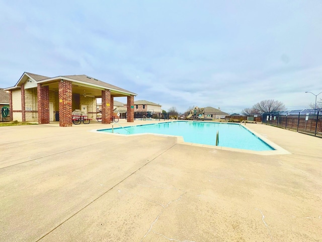 community pool featuring a patio and fence