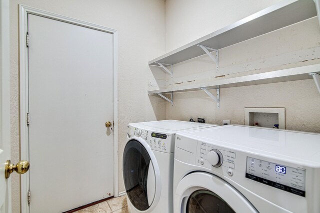 clothes washing area featuring light tile patterned floors, laundry area, and washing machine and clothes dryer