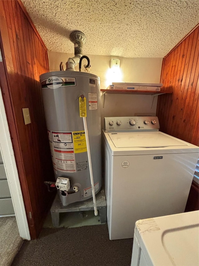 laundry area with wood walls, washer / clothes dryer, and gas water heater