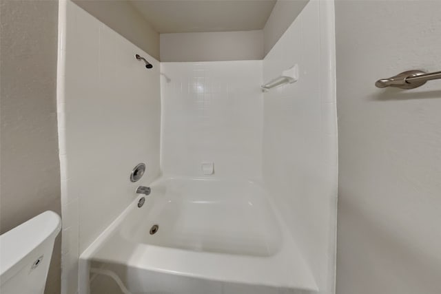 bathroom with tiled shower / bath combo and toilet