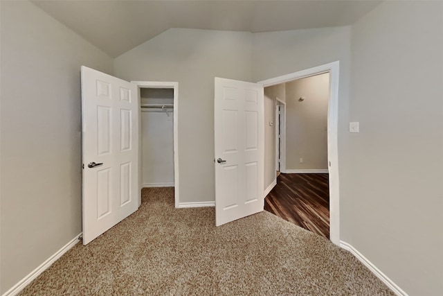 unfurnished bedroom with vaulted ceiling, carpet, and a closet