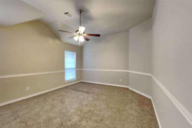 carpeted spare room featuring lofted ceiling and ceiling fan