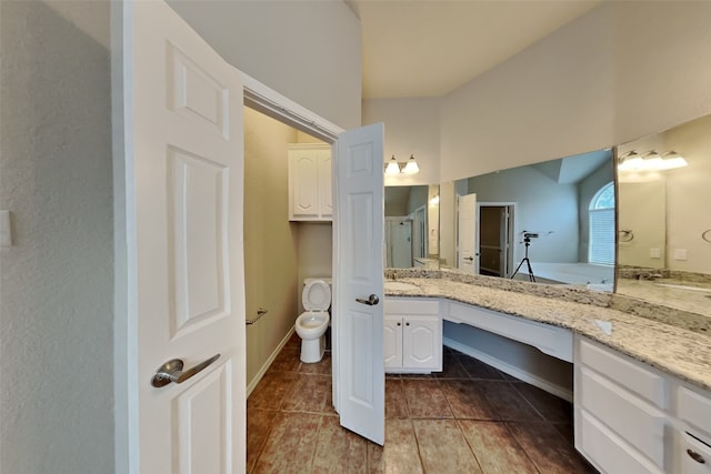 bathroom with tile patterned flooring, vanity, toilet, and walk in shower