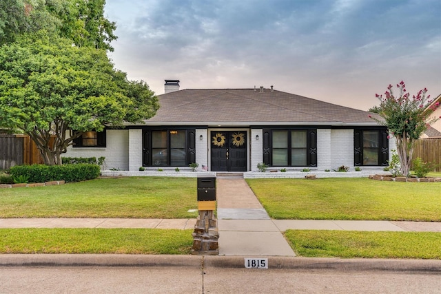 ranch-style house featuring a lawn and french doors